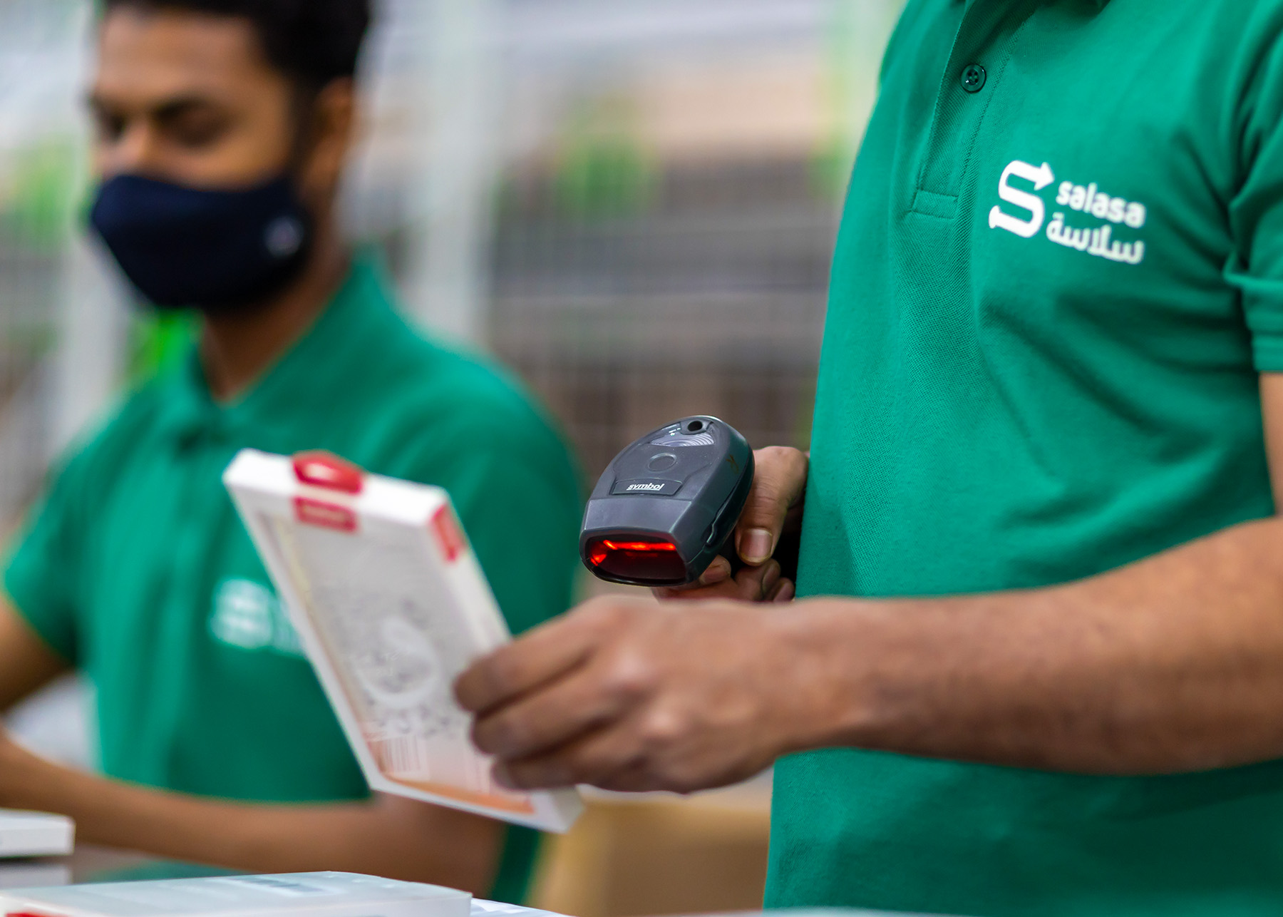 Hand using barcode scanner in Salasa warehouse