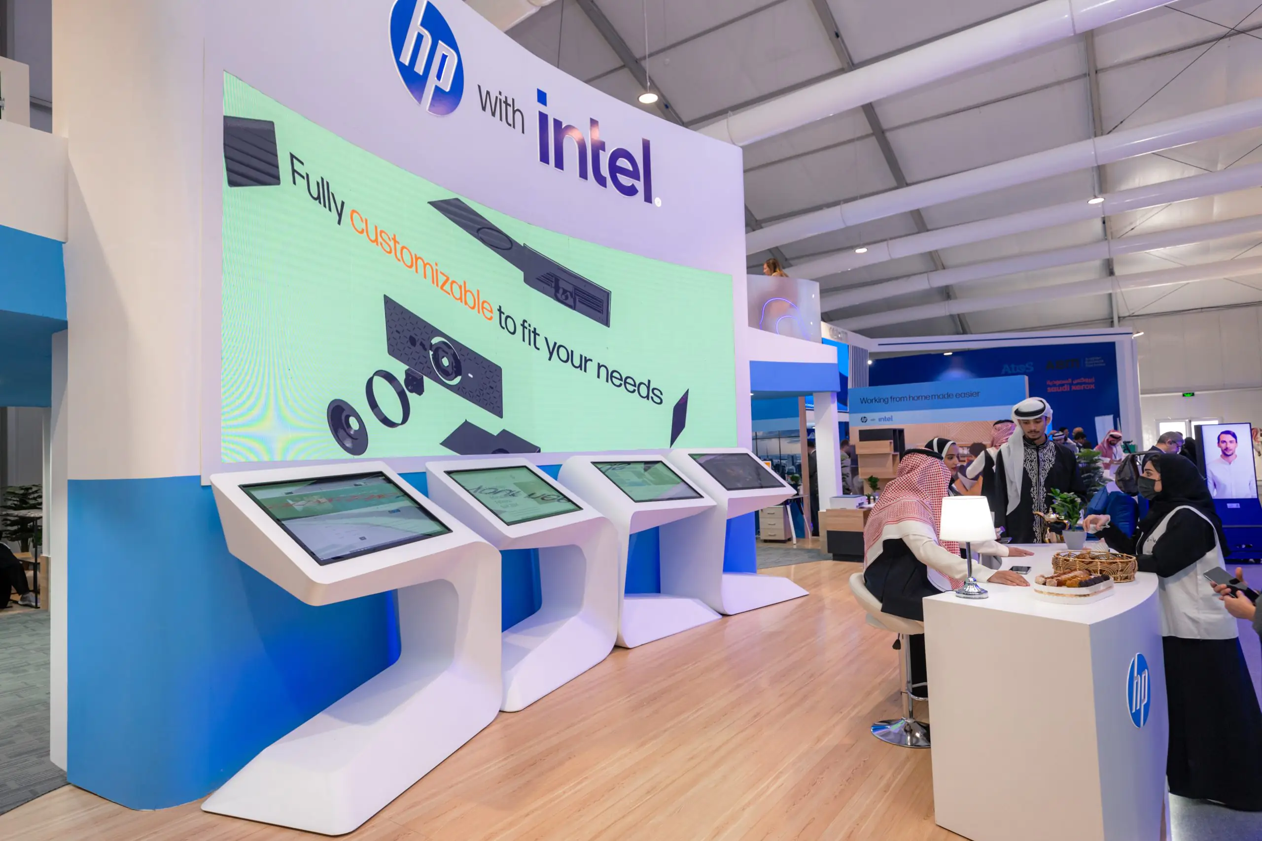 HP booth at the Leap event featuring interactive touchscreen displays and customizable product demos, with attendees engaging at the booth