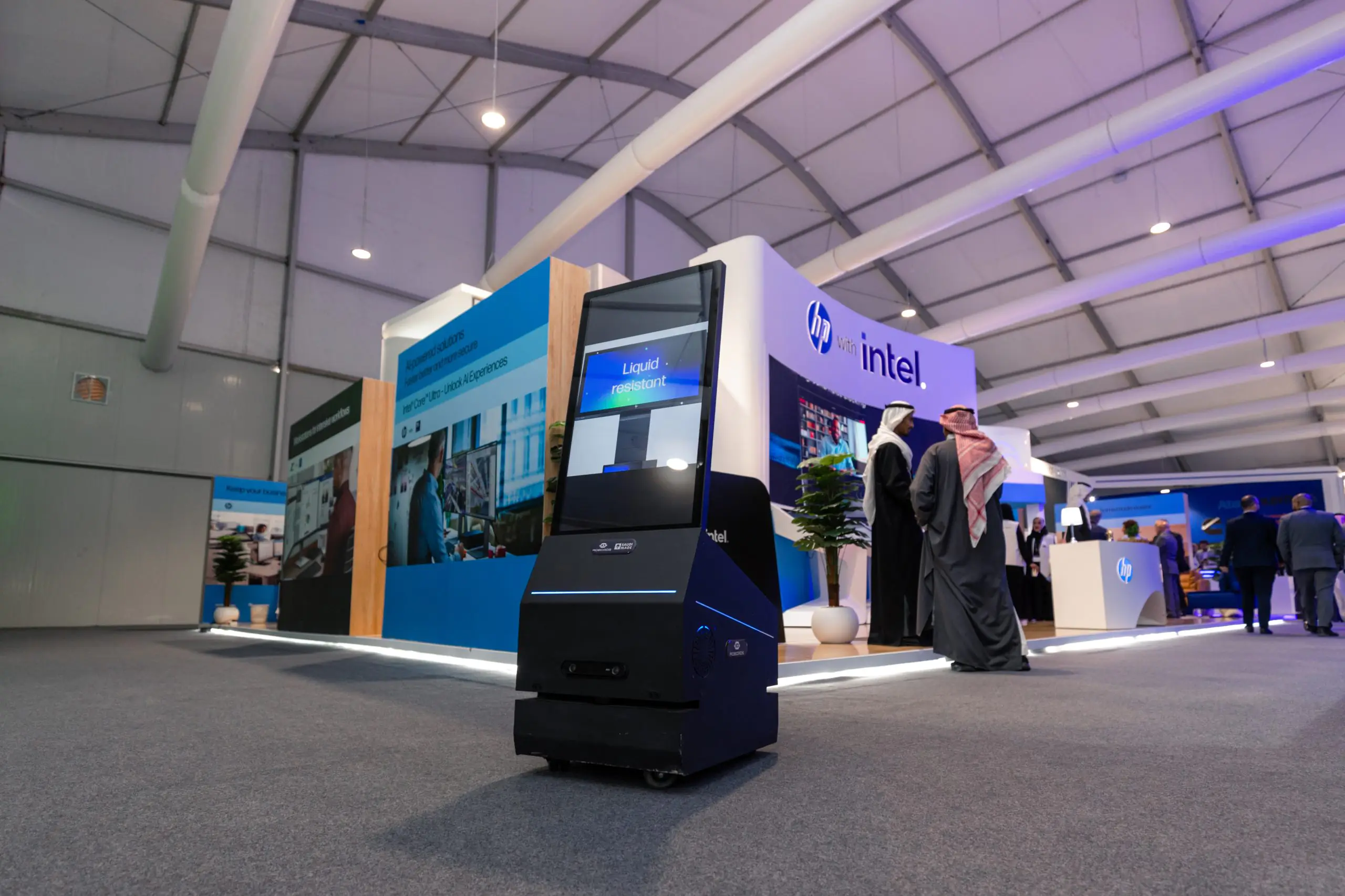 HP and Intel booth at the Leap event, featuring a liquid-resistant digital display robot and attendees interacting in the background