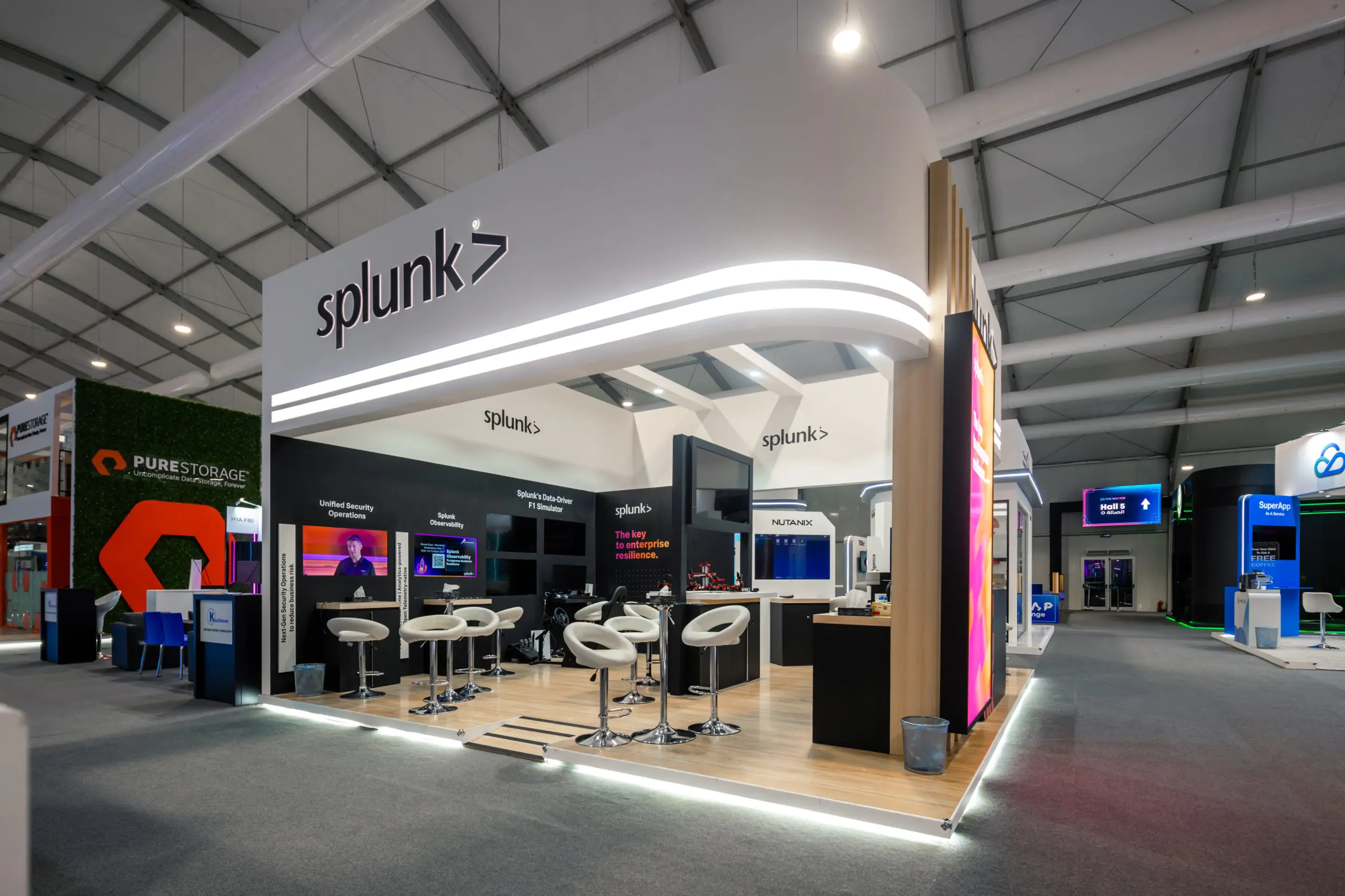 Splunk booth at the Leap event featuring interactive displays on security operations, observability, and an F1 simulator