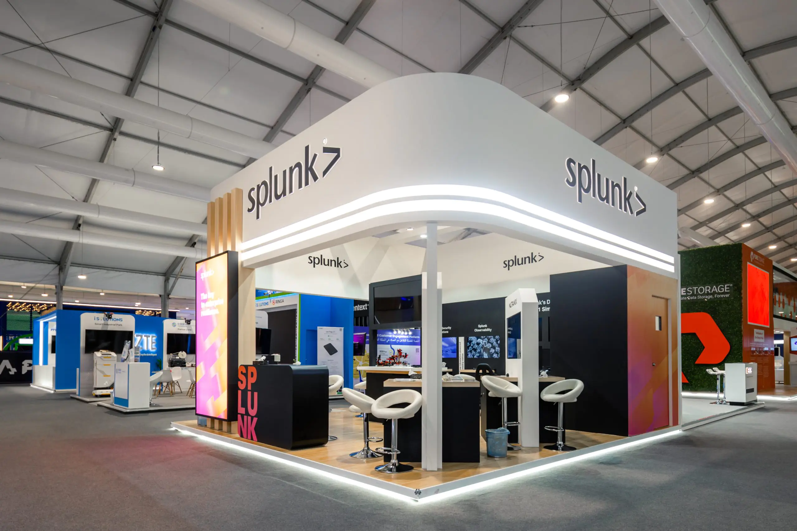 Splunk booth at the Leap event featuring a modern design with interactive displays on observability, security, and an F1 simulator