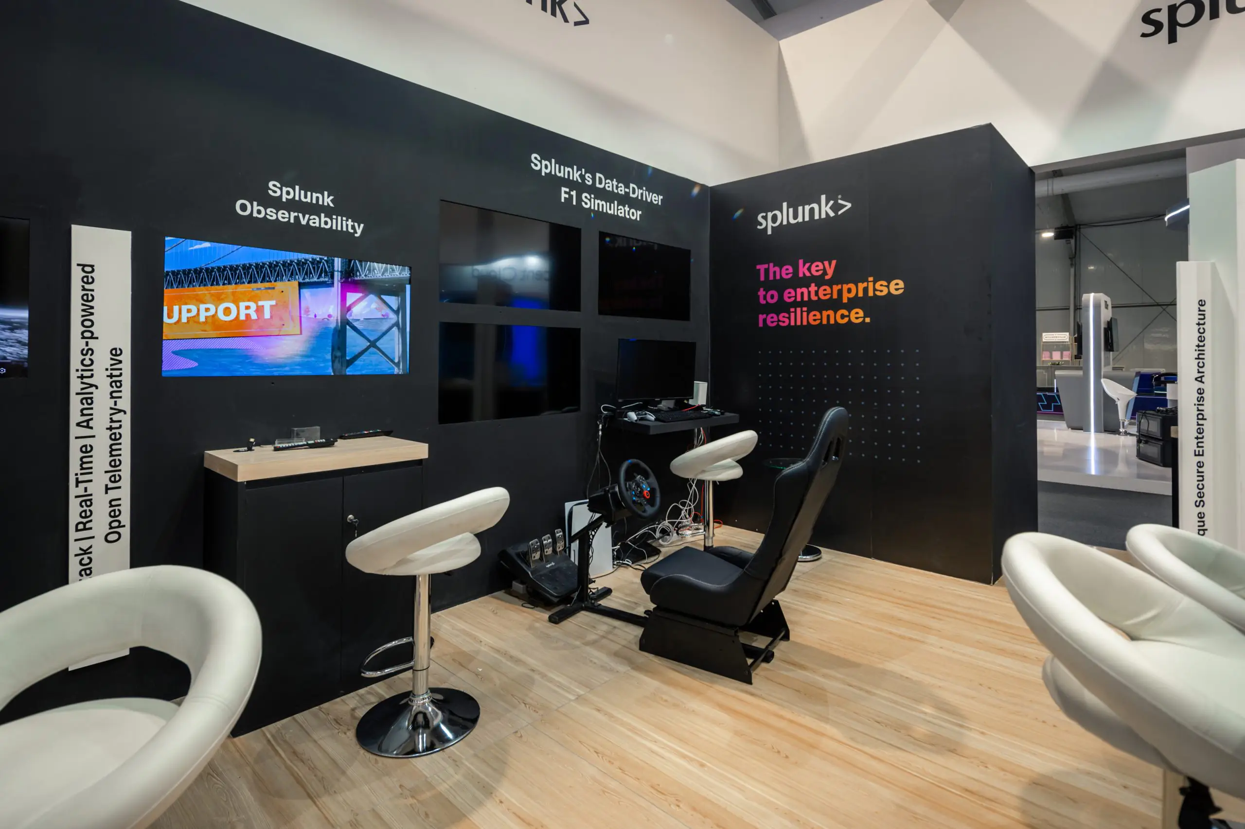 Splunk booth featuring observability displays and a data-driven F1 simulator, promoting enterprise resilience at the Leap event.