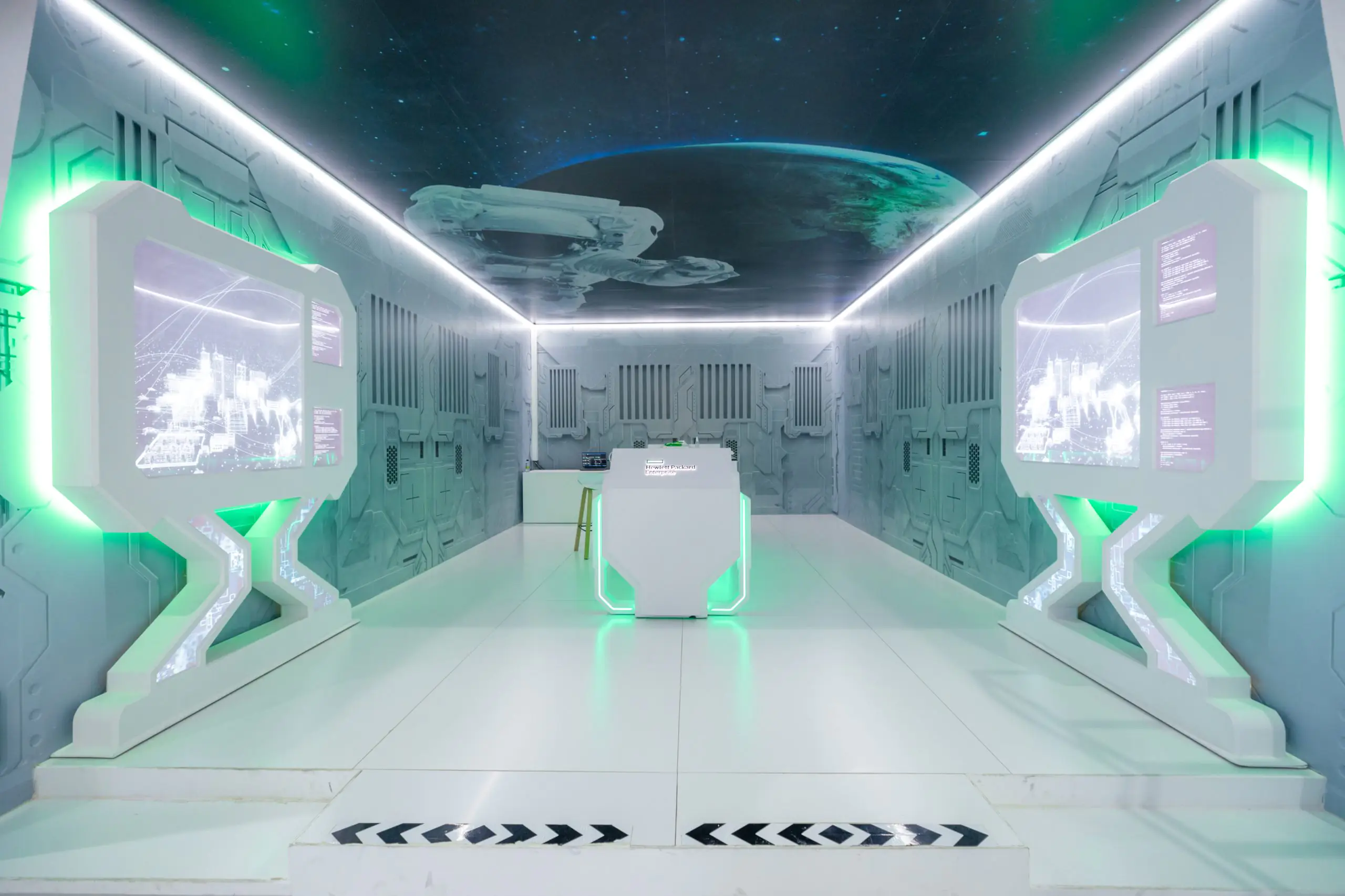 Futuristic HPE booth at LEAP, designed like a spaceship, with digital screens, green lighting, central console, and space-themed ceiling