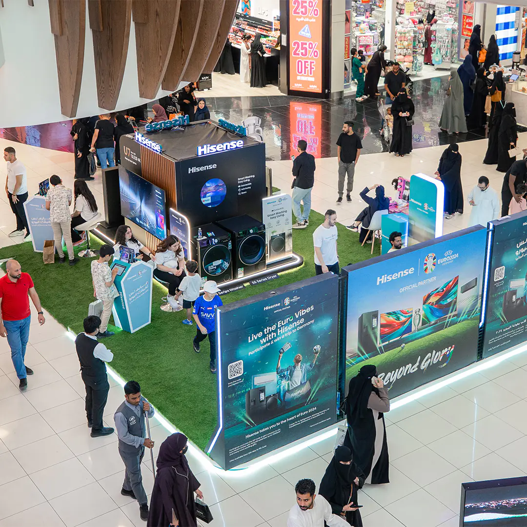 Crowded mall booth showcasing Hisense TVs, washing machines, and other appliances, promoting UEFA Euro 2024 partnership with interactive displays