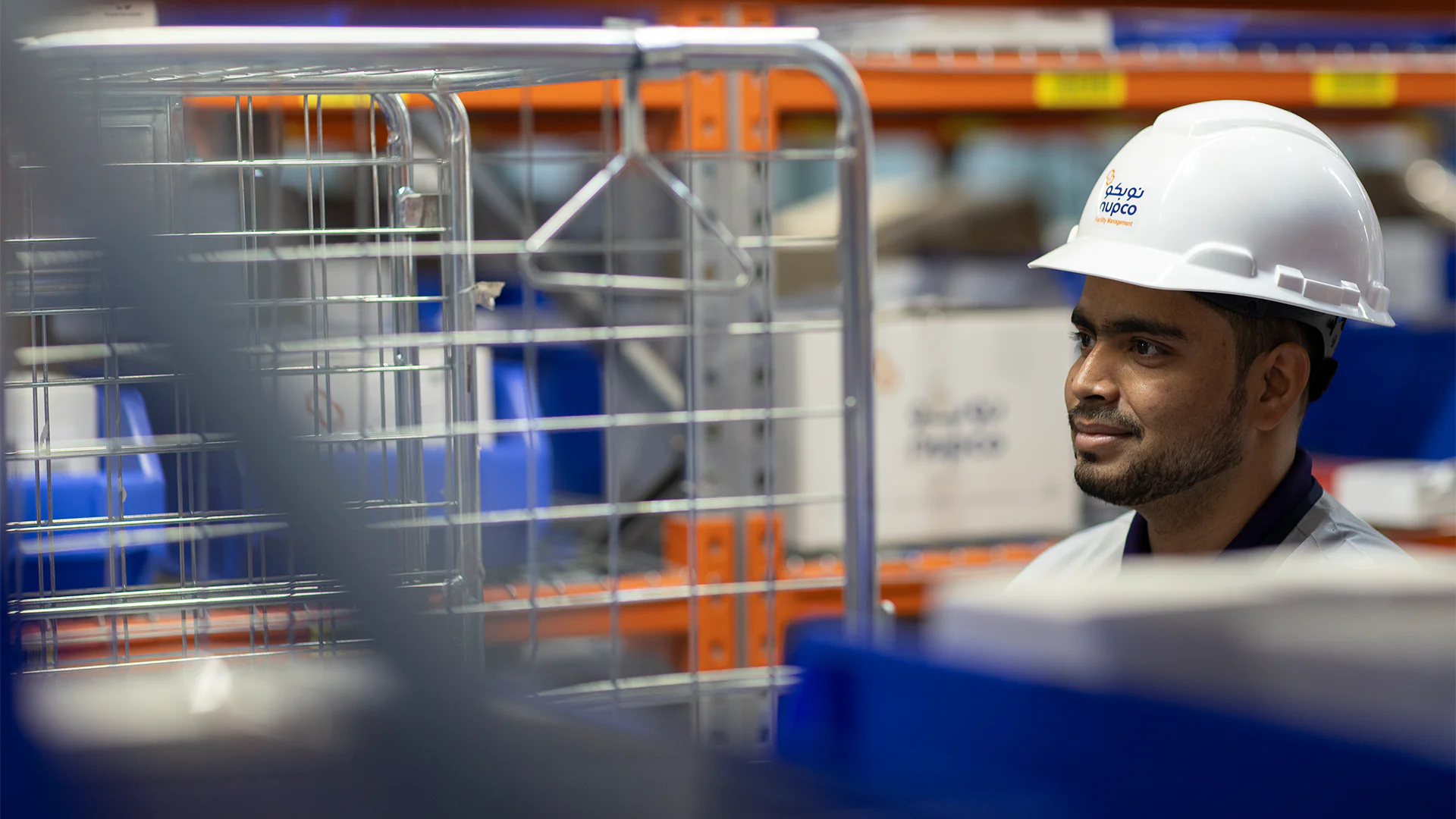 Close-up of a NUPCO warehouse employee in a hard hat, focused on ensuring smooth and safe logistics operations