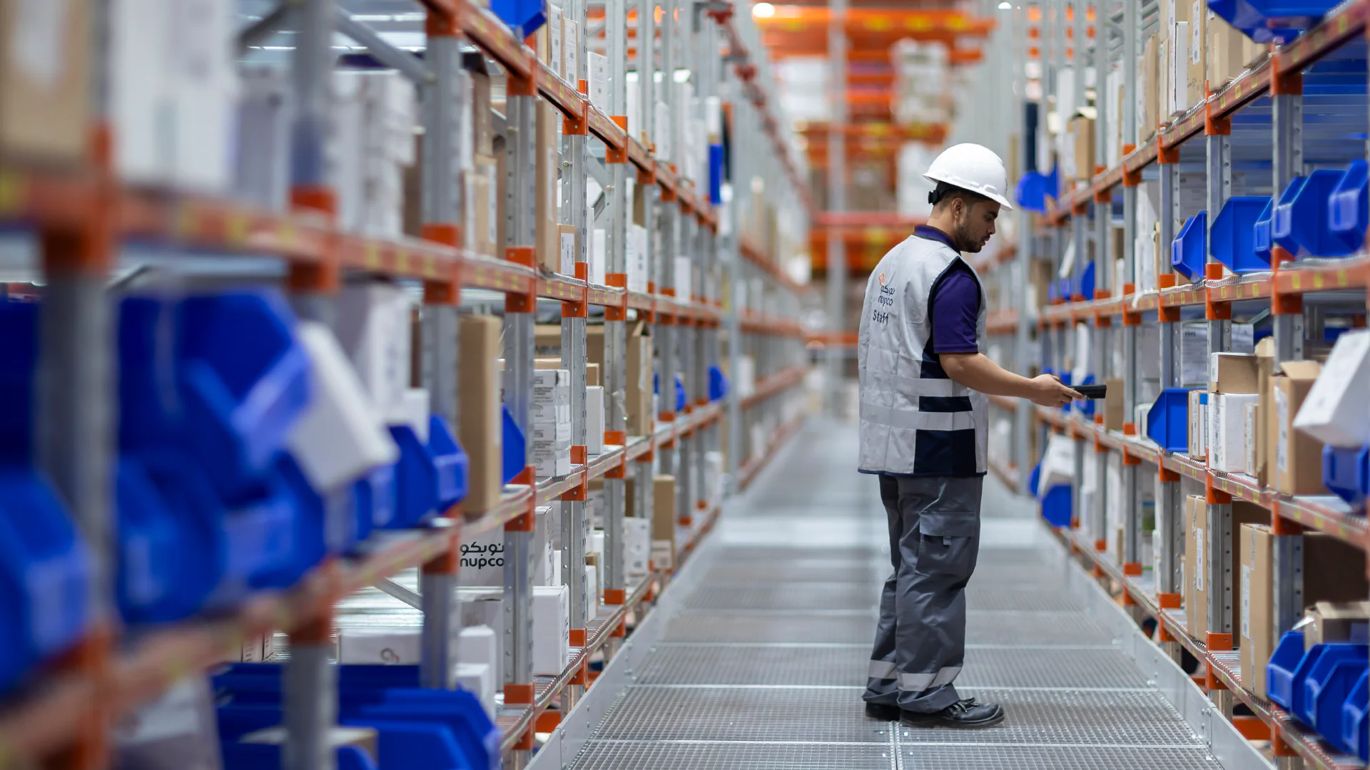 Warehouse worker at NUPCO inspecting inventory, ensuring accurate stock management and seamless operations in the warehouse