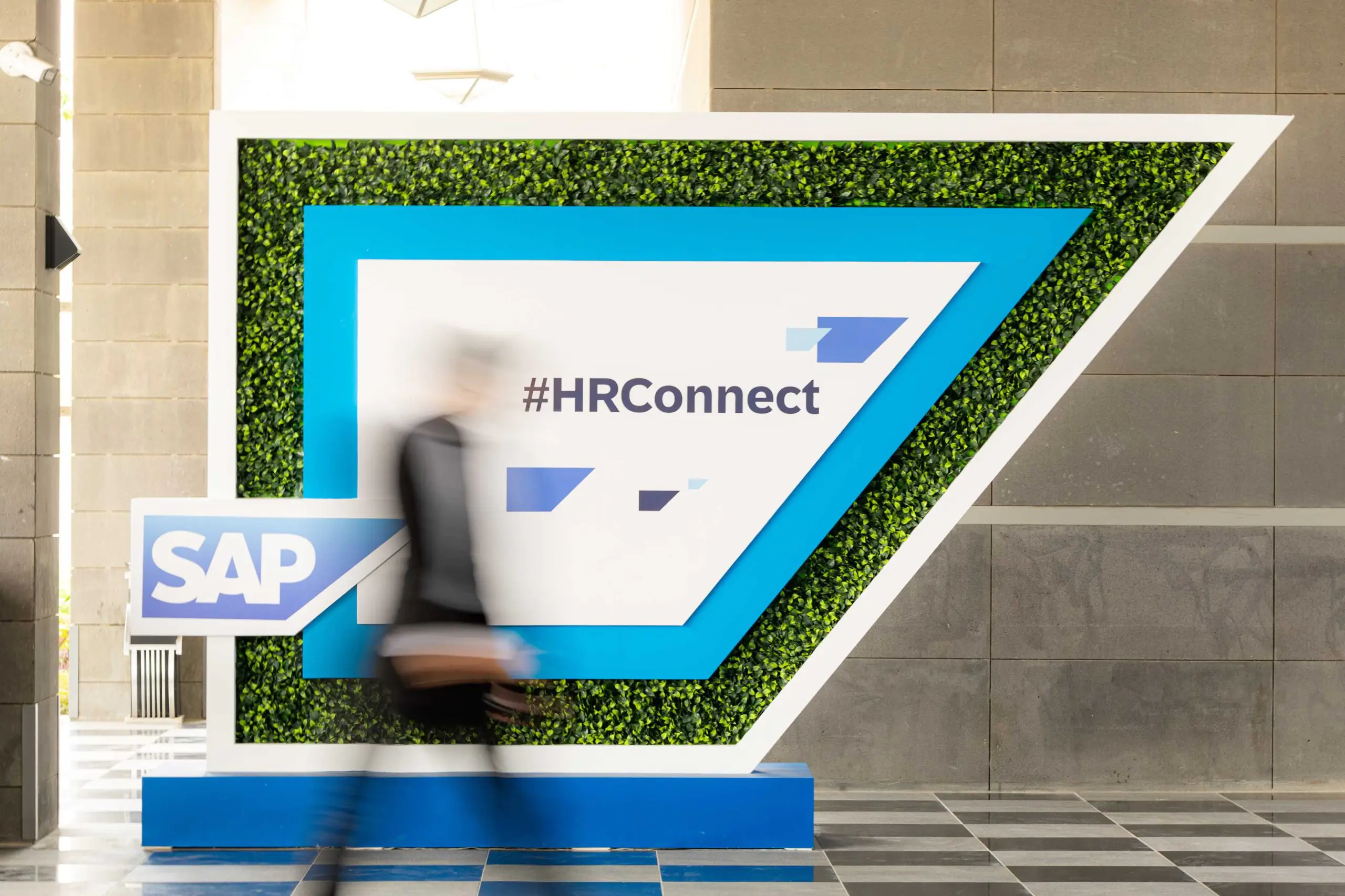 A man walks alongside SAP sign at HR Connect event in Riyadh