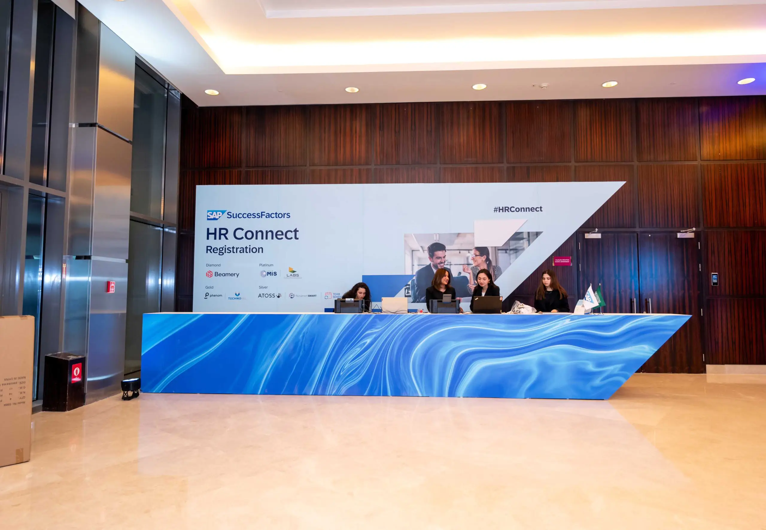 Registration desk for SAP HR Connect in Riyadh with team assisting attendees.