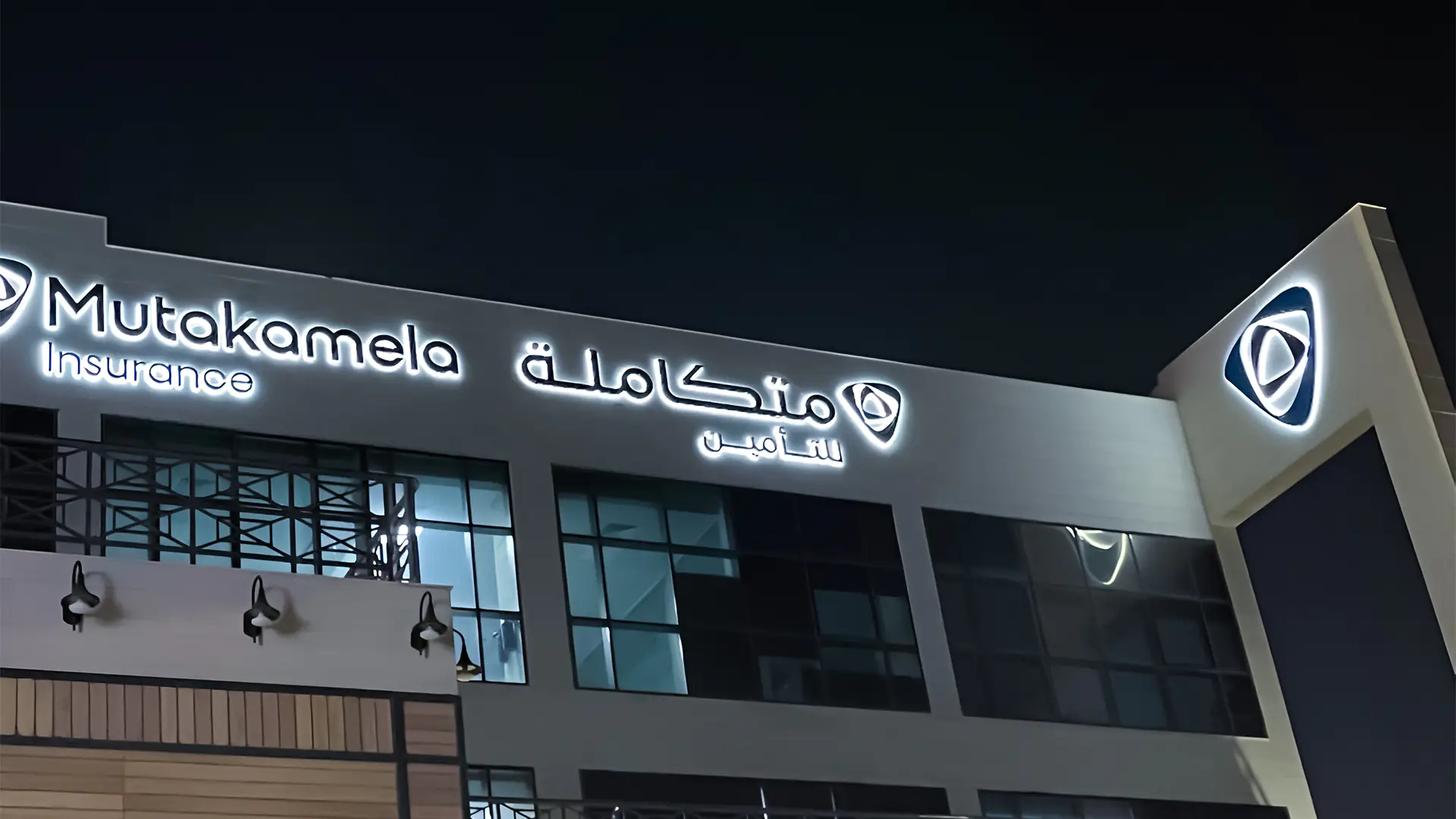 Bright night view of Mutakamela's office with glowing signage, symbolizing a fresh chapter of trust and innovation.