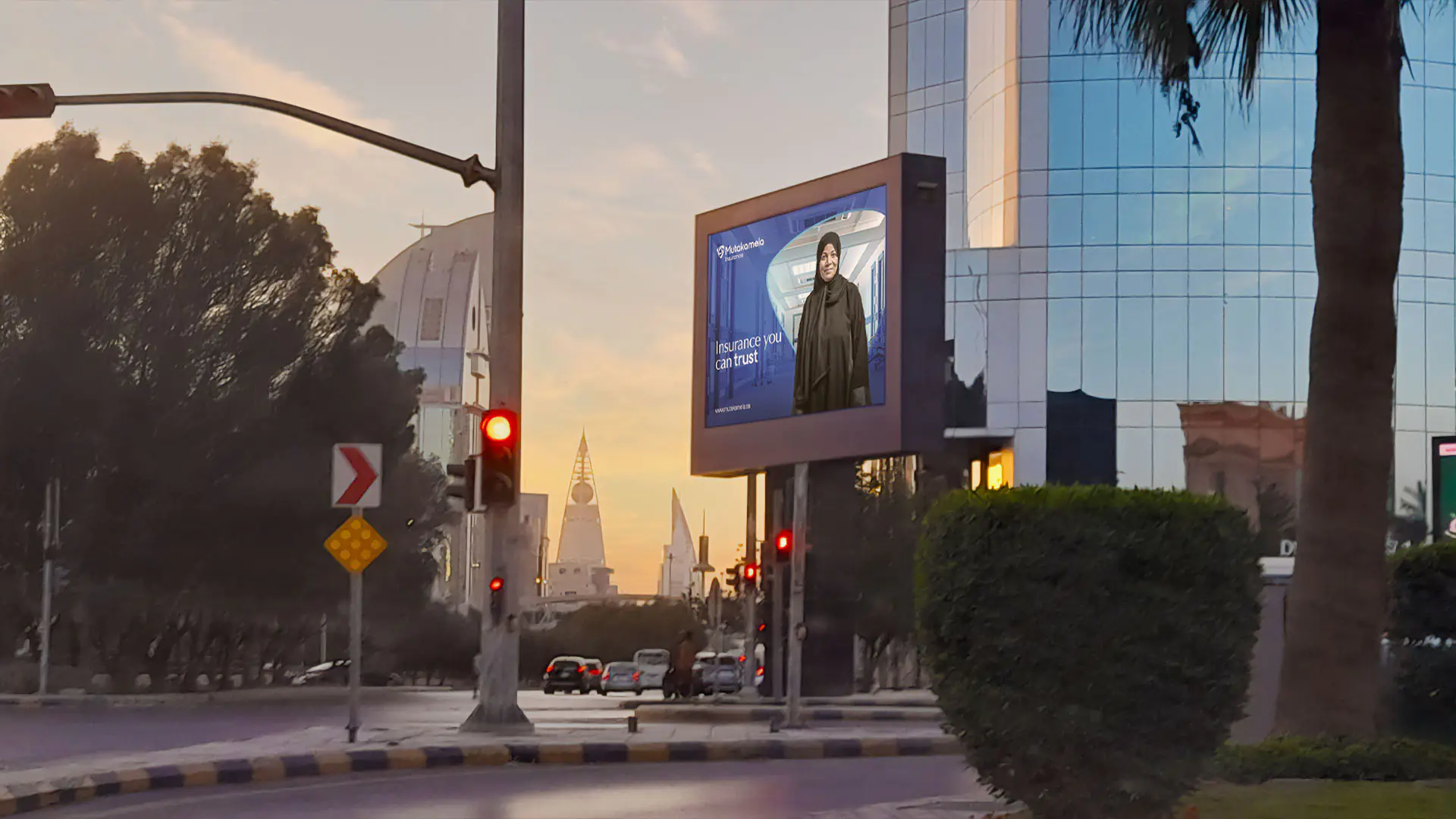 Illuminated billboard in Riyadh featuring Mutakamela’s new branding and the trusted message: تأمين تعتمد عليه.