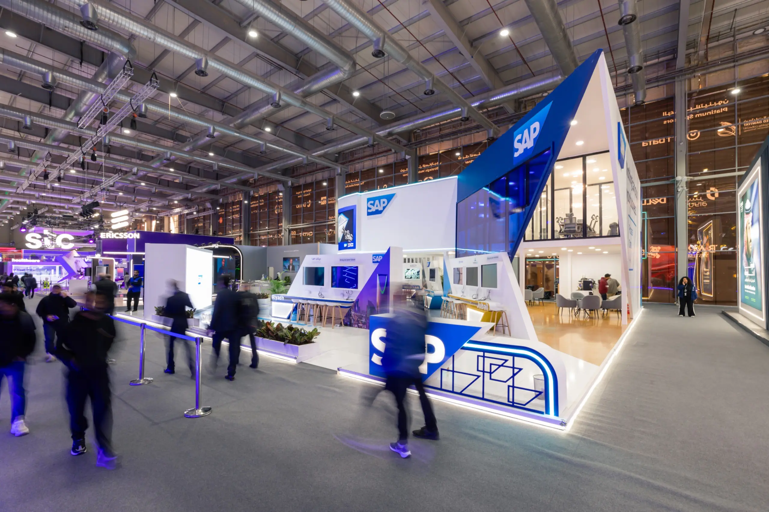 A spacious SAP trade show booth with an angular design, multiple levels, and interactive demo stations.