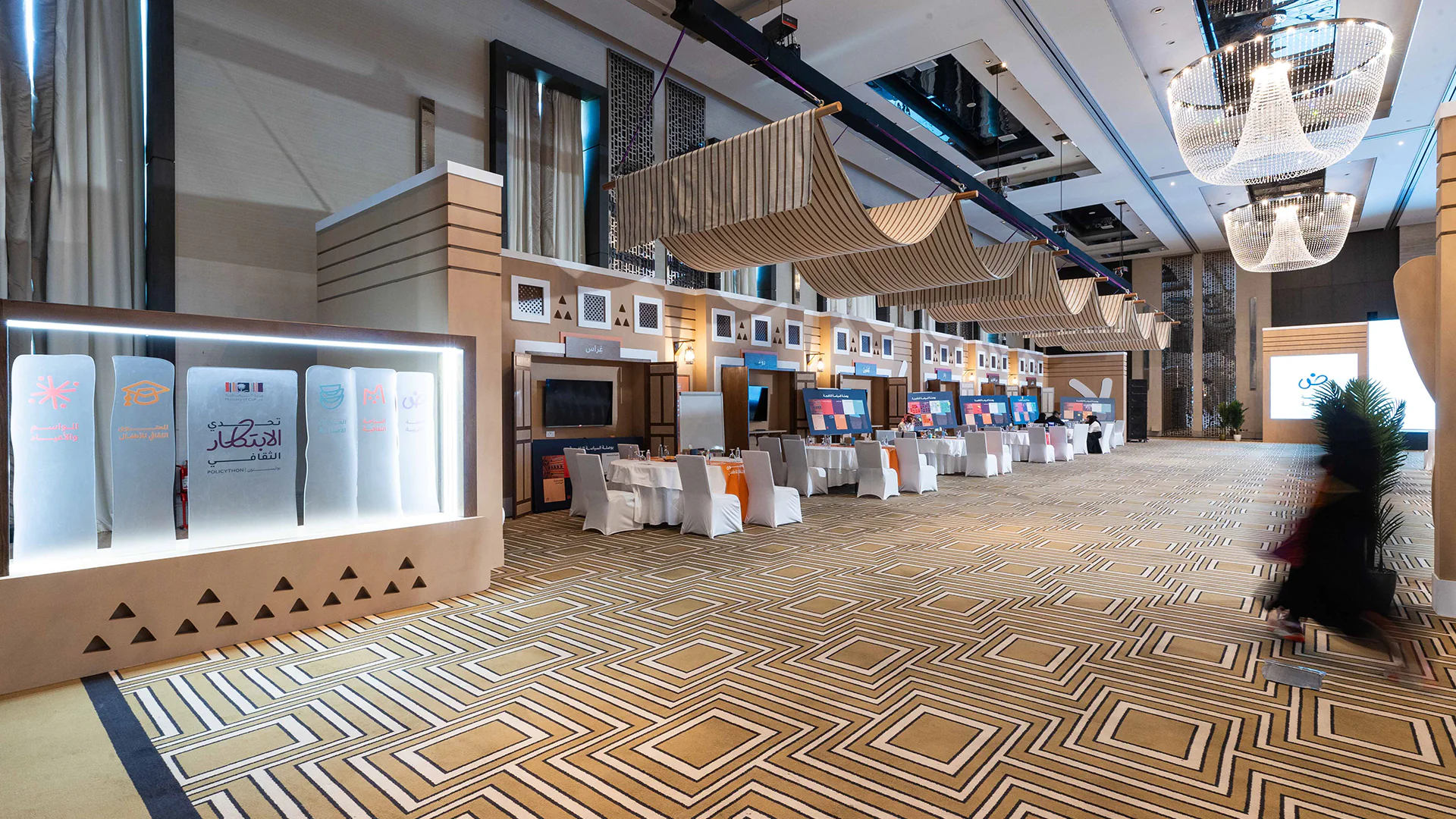 A wide view of the policython bootcamp space featuring booths, decor, and traditional design elements.