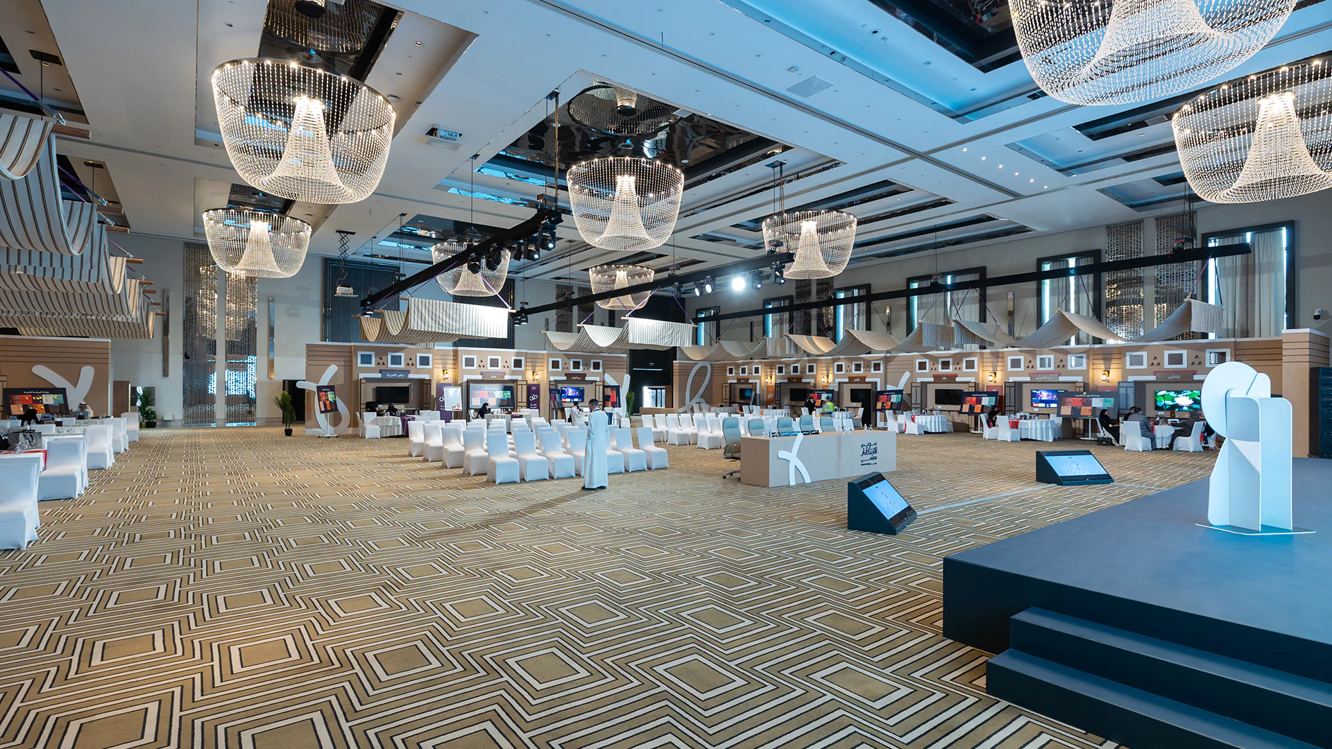 Full venue shot showing the audience seating, stage setup, and immersive cultural decor elements.
