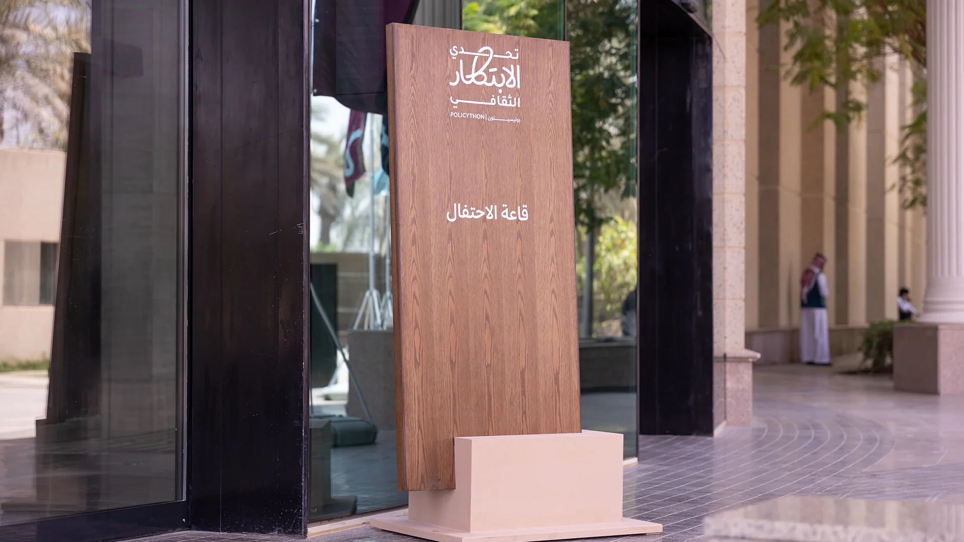Wooden sign with the Policython logo marking the entrance to the celebration hall.