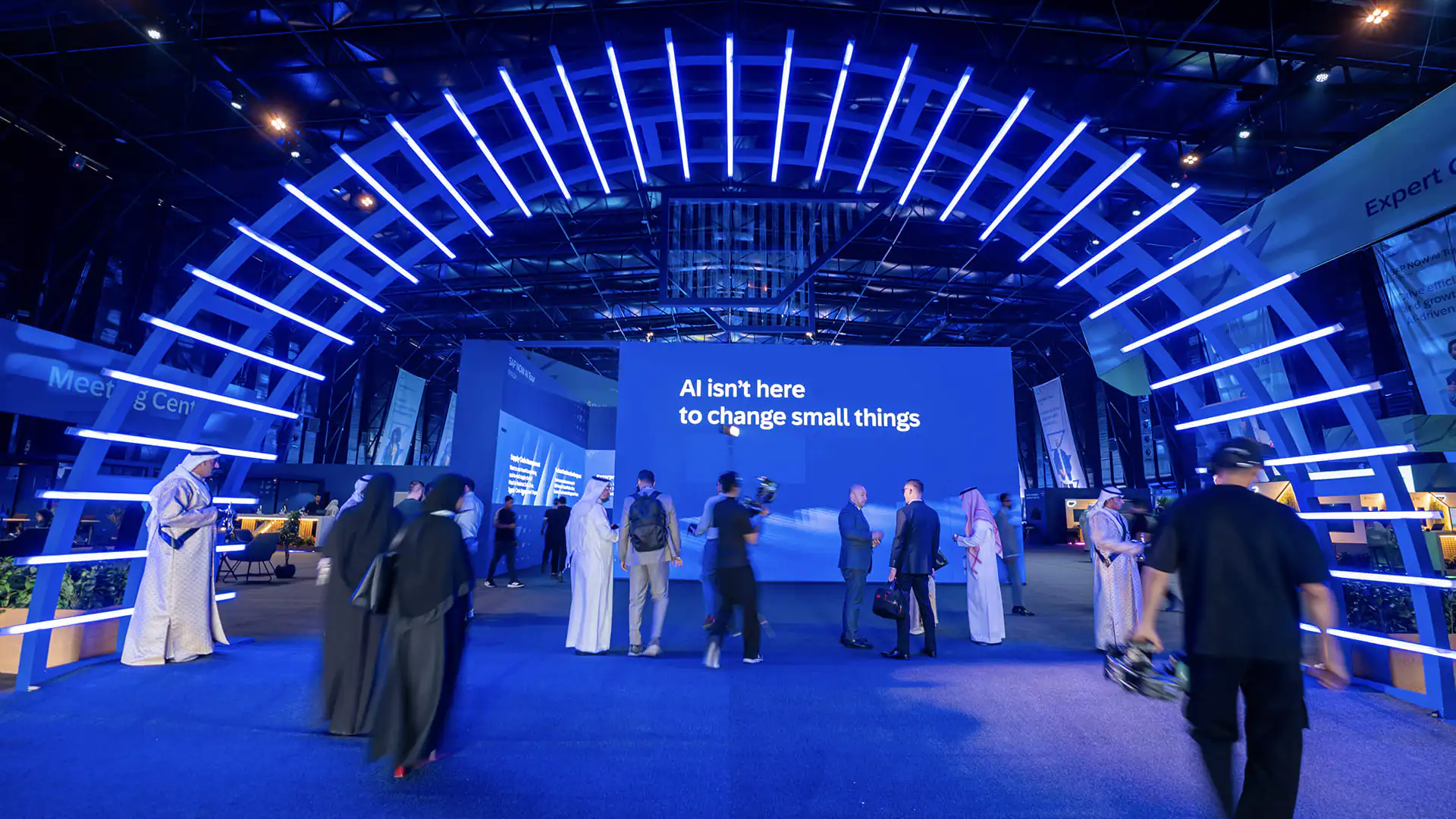 Attendees walk under a large blue LED arch inside SAP NOW AI Tour Riyadh’s main hall.