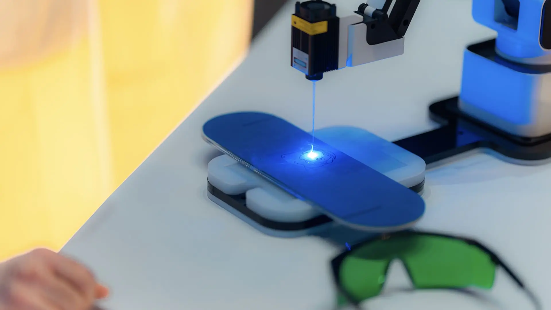 Close-up of robotic laser engraving demo glowing blue at SAP NOW AI Tour.