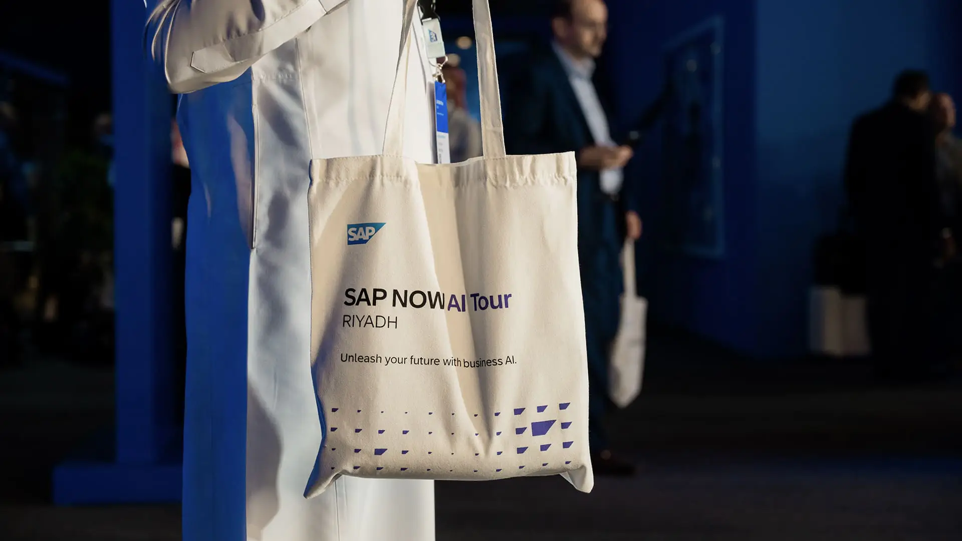 Close-up of SAP NOW AI Tour Riyadh tote bag held by an attendee.