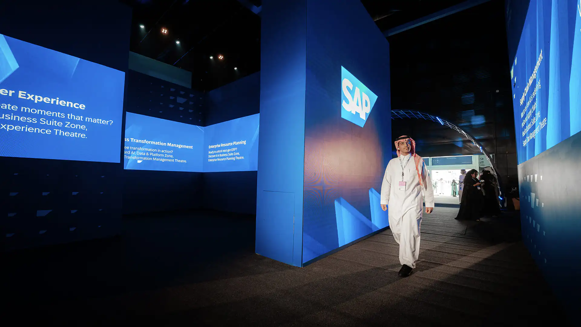 Guest walking through the SAP AI immersive maze with blue-lit walls and content screens.