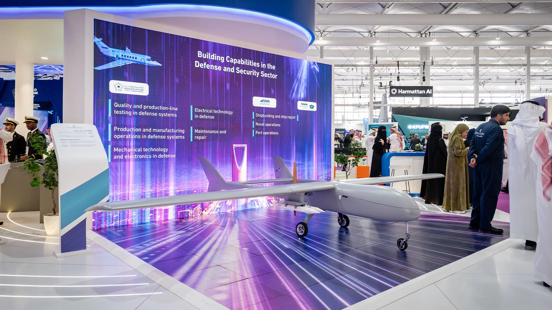 College of Excellence booth drone display with floor LED runway and large curved screen at World Defense Show 2026.