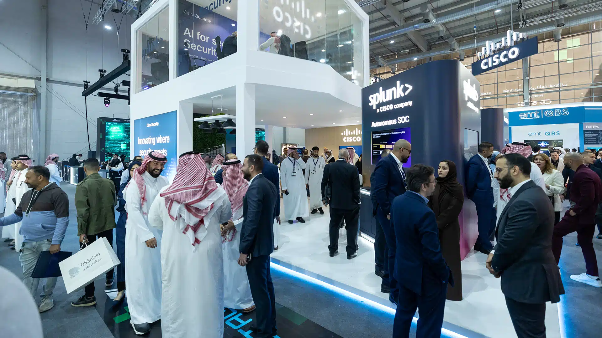 Crowd networking at Cisco booth beside Splunk partner pod at Black Hat 2025.