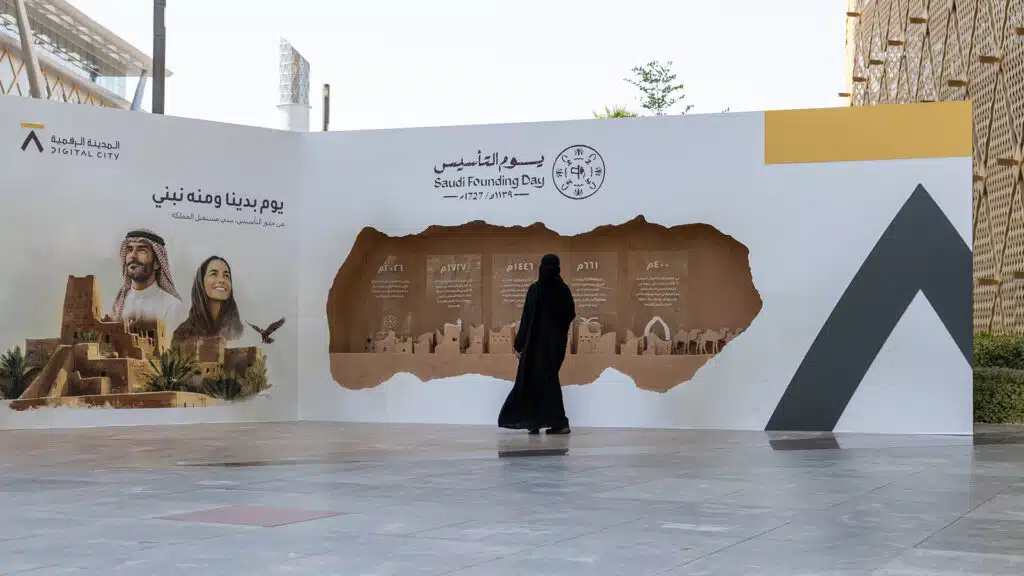 Visitor viewing Saudi Founding Day timeline installation at Digital City