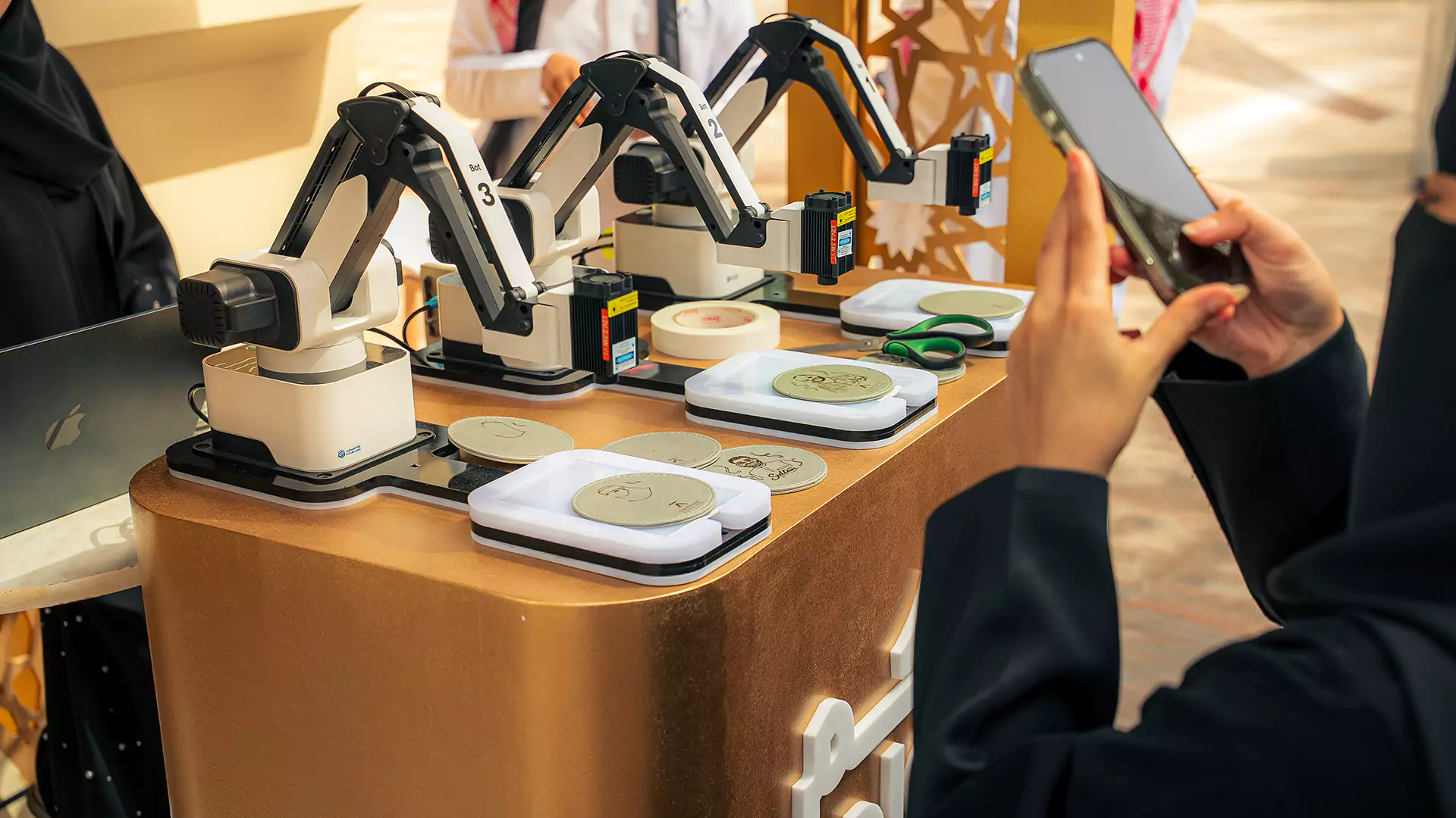 Interactive laser engraving robots creating personalized souvenirs at event booth