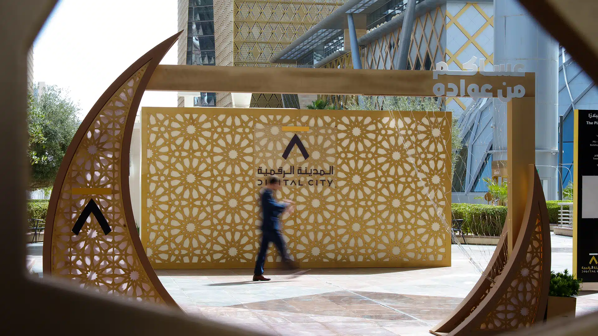Decorative Ramadan installation with patterned panels and passerby in motion at Digital City