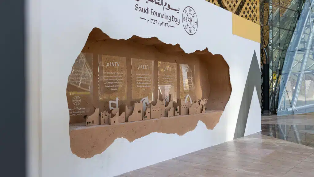 Close-up of Saudi Founding Day timeline panels and heritage city model